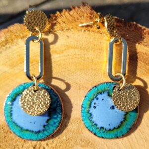Boucles d'oreilles émaux bleu posées sur un rond de bois et vues de près